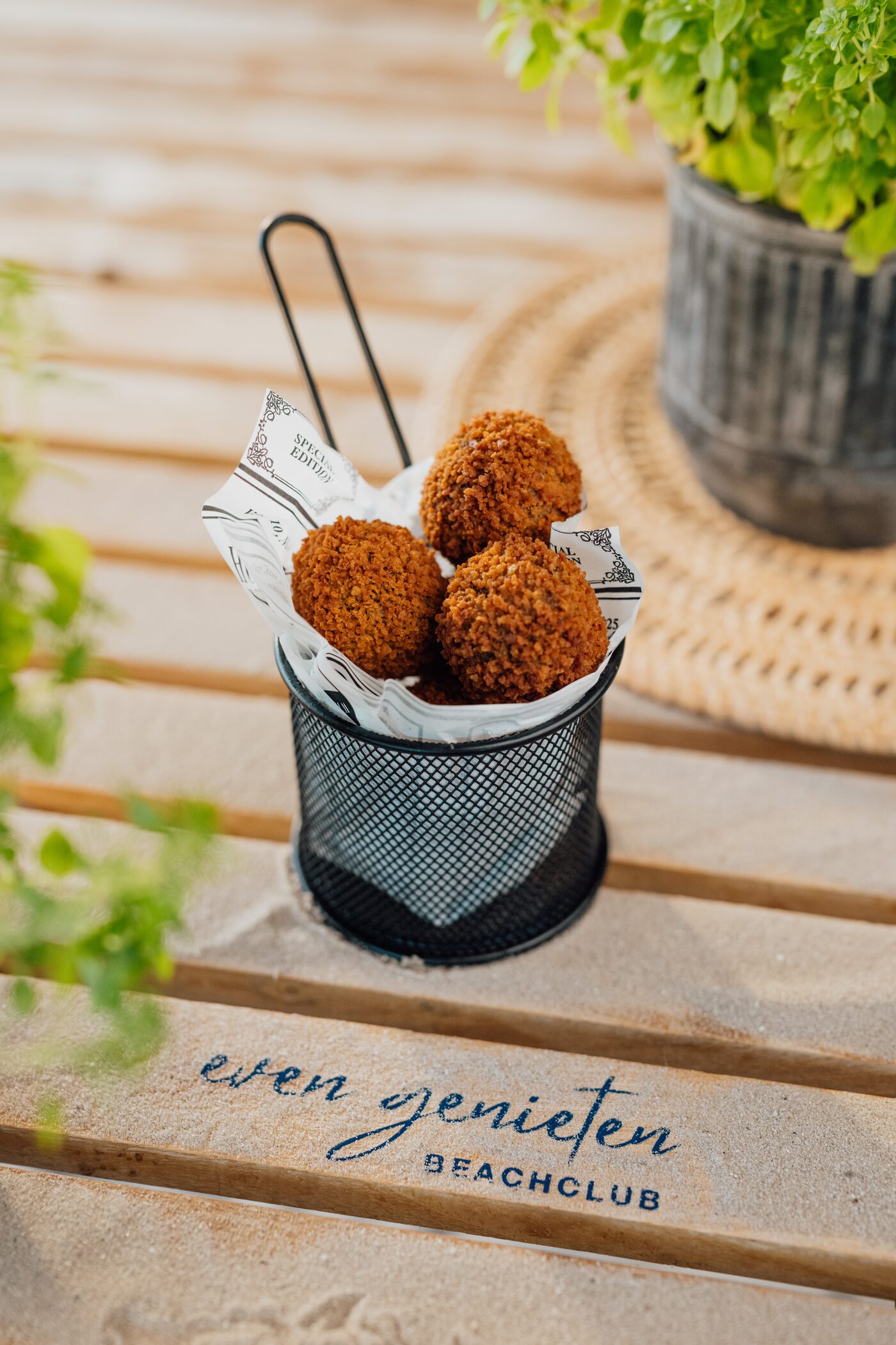 Bitterballen im Drahtkorb auf Even-Genieten-Beachclub-Holzterrasse
