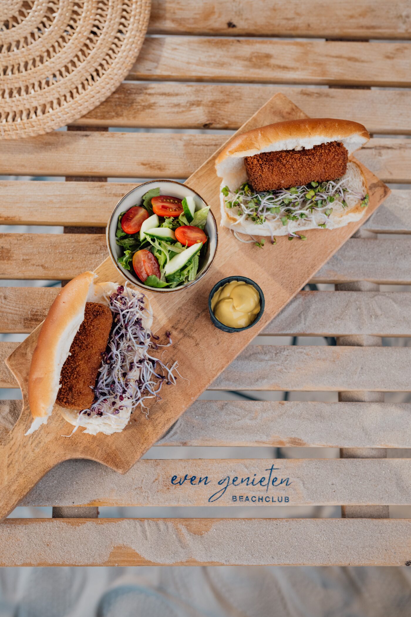 Broodjes mit Kroketten und Sprossen auf gebrandetem Even-Genieten-Beachclub-Holzbrett, Vogelperspektive